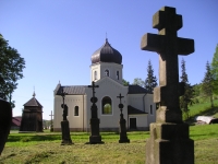 Stary cmentarz emkowski na tle cerkwi.